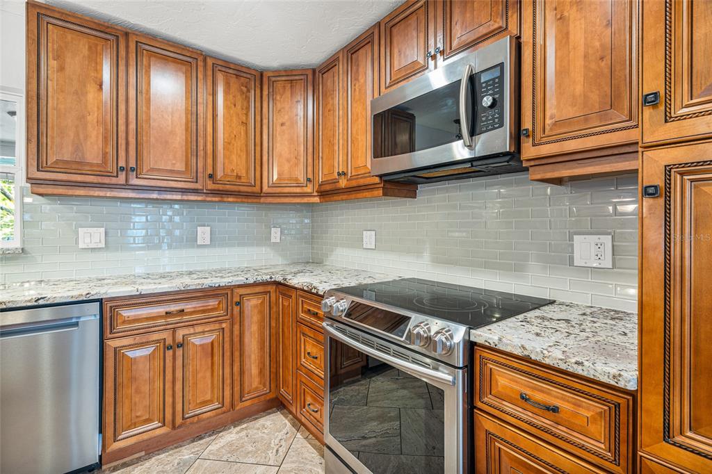 4207 Charing Cross Road Sarasota, FL 34241 - Photo 12 of 36 a kitchen with granite countertop cabinets stainless steel appliances granite counter tops and a window