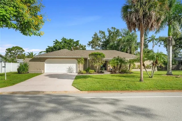 a front view of a house with a yard and trees
