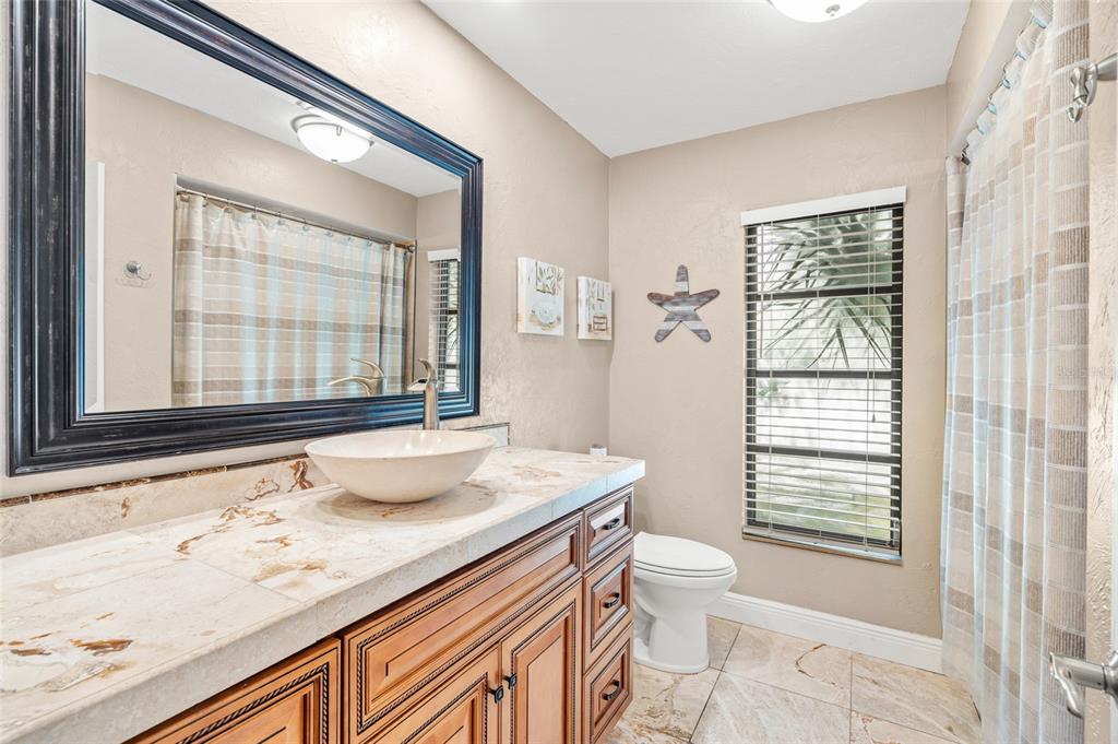 4207 Charing Cross Road Sarasota, FL 34241 - Photo 30 of 36 a bathroom with a granite countertop sink toilet and shower