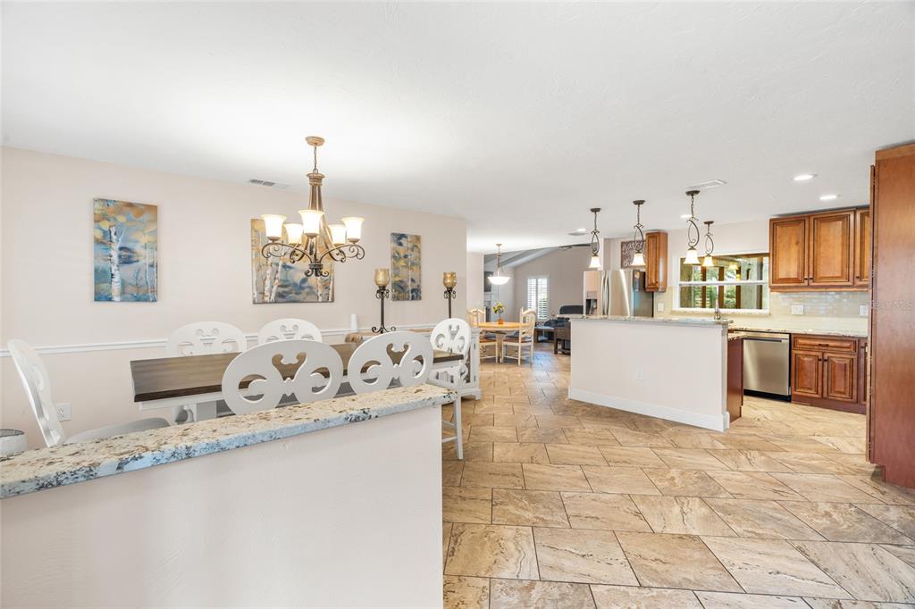4207 Charing Cross Road Sarasota, FL 34241 - Photo 5 of 36 a large white kitchen with granite countertop a sink white cabinets and a granite counter tops