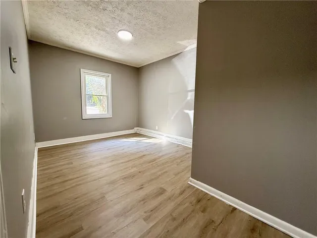an empty room with wooden floor and entrance