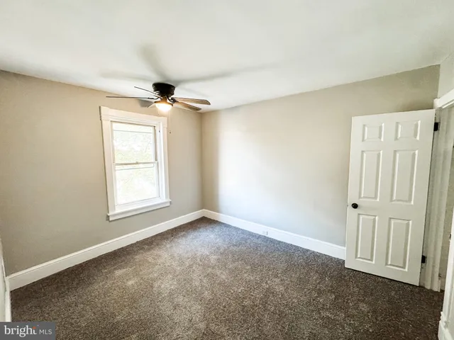 an empty room with windows and ceiling fan