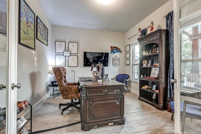 a view of a workspace with furniture and a window