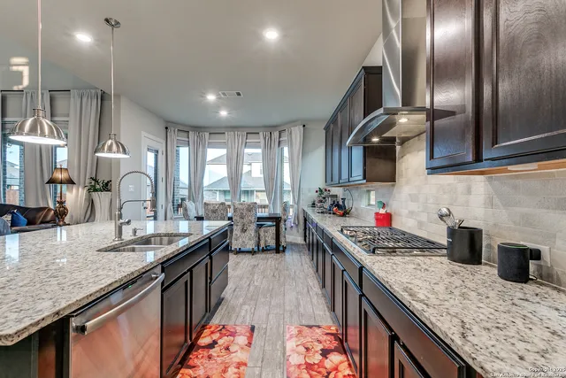 a kitchen that has a lot of cabinets a sink and a wooden floor