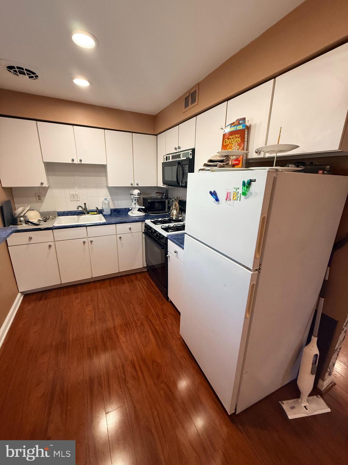 426 Parlin Street Philadelphia, PA 19116 - Photo 17 of 27 a kitchen with a refrigerator a stove top oven a sink and wooden floor