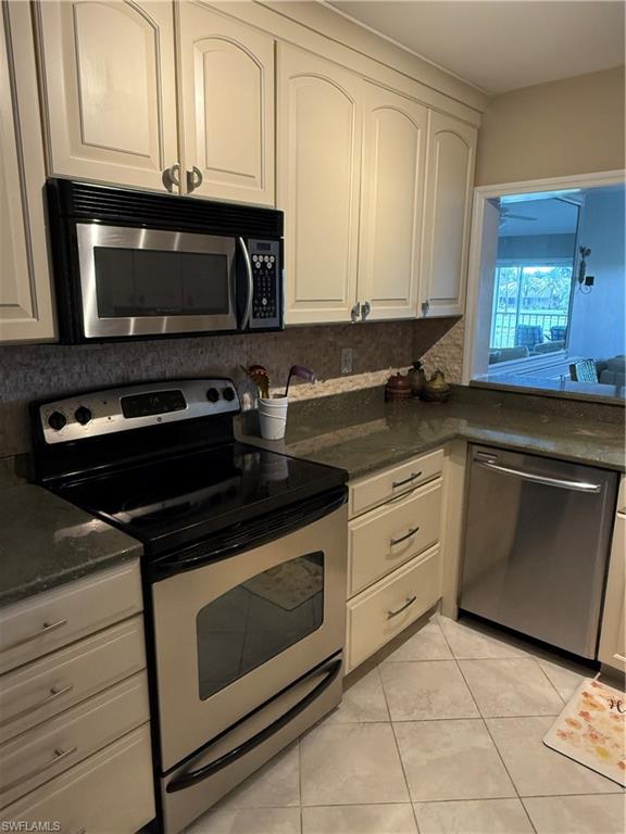 760 Augusta Boulevard, Unit D204 Naples, FL 34113 - Photo 23 of 32 a kitchen with a stove and a microwave