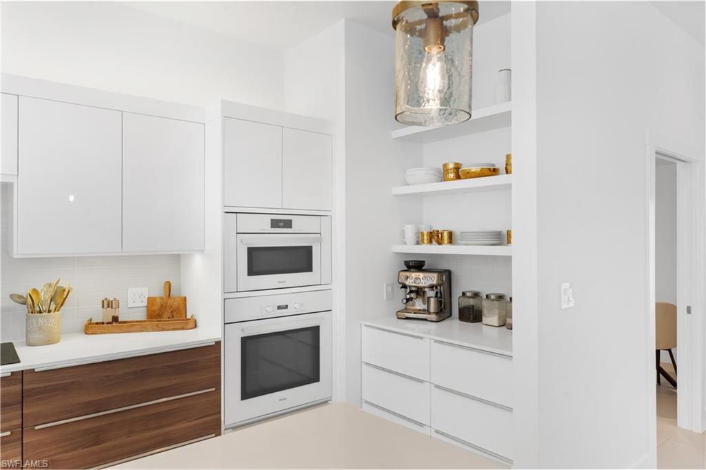 516 Neapolitan Lane Naples, FL 34103 - Photo 9 of 49 Kitchen featuring modern cabinets, white cabinetry, and open shelves