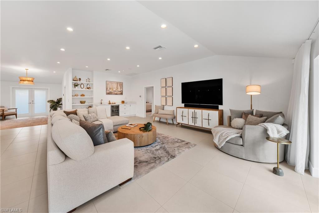 516 Neapolitan Lane Naples, FL 34103 - Photo 11 of 49 Living room with recessed lighting, tile patterned flooring, french doors, vaulted ceiling, and beverage cooler