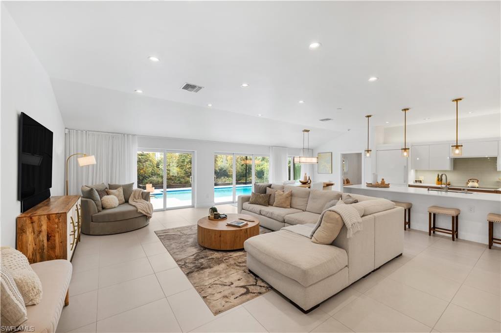 516 Neapolitan Lane Naples, FL 34103 - Photo 12 of 49 Living area with recessed lighting, light tile patterned floors, and high vaulted ceiling