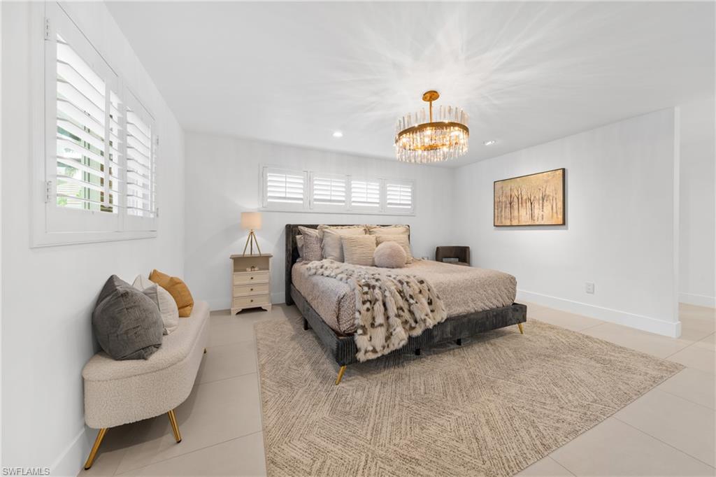 516 Neapolitan Lane Naples, FL 34103 - Photo 17 of 49 Bedroom featuring light tile patterned floors, a chandelier, and recessed lighting
