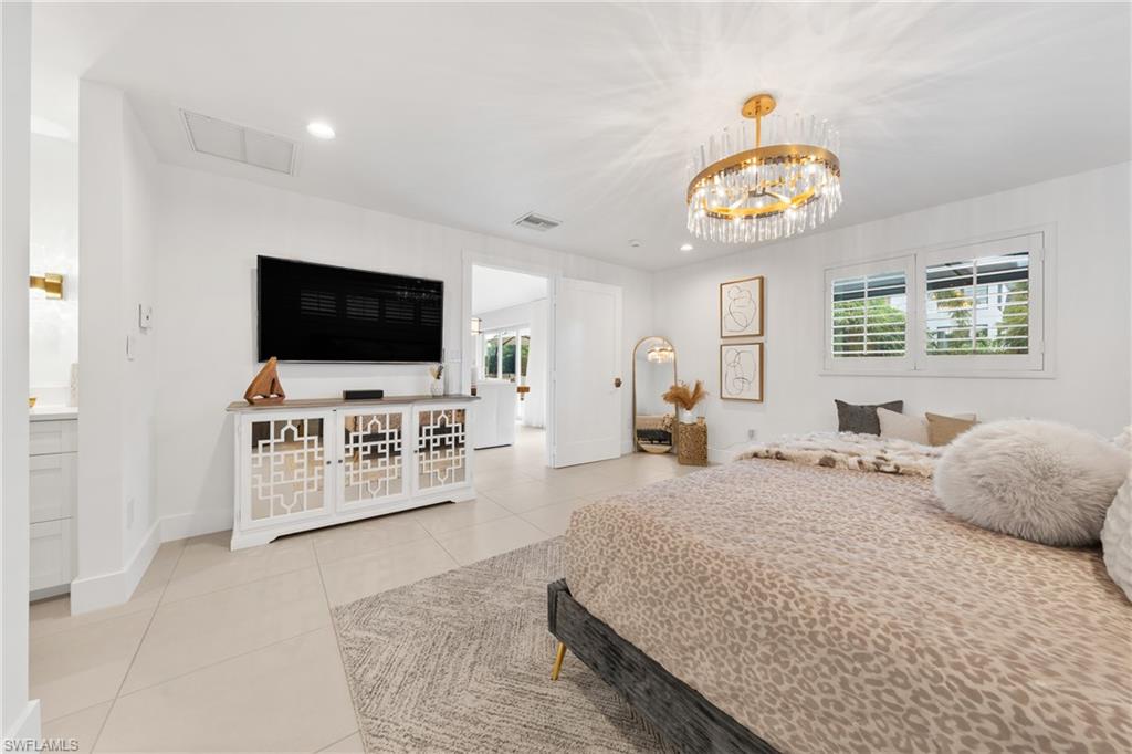 516 Neapolitan Lane Naples, FL 34103 - Photo 18 of 49 Bedroom with recessed lighting, light tile patterned floors, and a chandelier