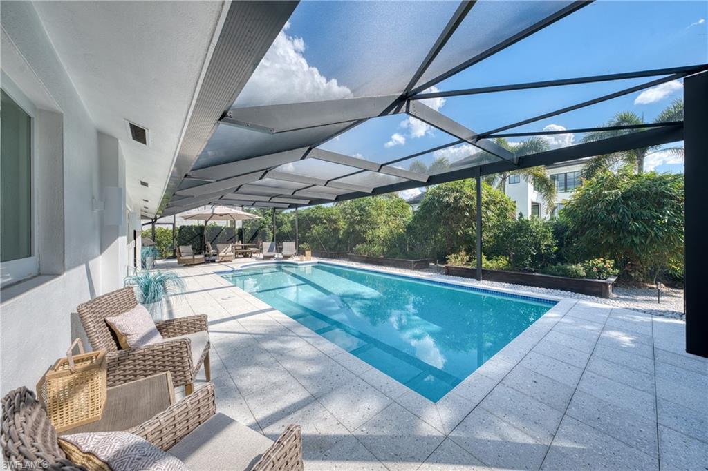 516 Neapolitan Lane Naples, FL 34103 - Photo 32 of 49 Swimming pool featuring glass enclosure, a patio, and a sunroom