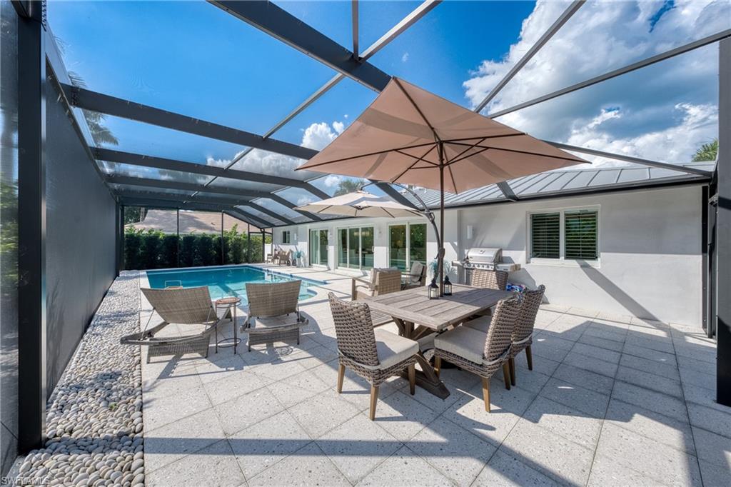 516 Neapolitan Lane Naples, FL 34103 - Photo 33 of 49 View of patio with a sunroom, glass enclosure, an outdoor pool, outdoor dining area, and area for grilling
