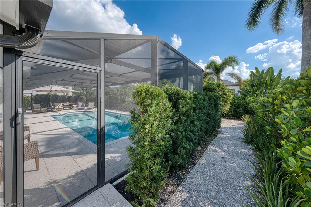 516 Neapolitan Lane Naples, FL 34103 - Photo 35 of 49 Swimming pool featuring a lanai, a sunroom, and a patio