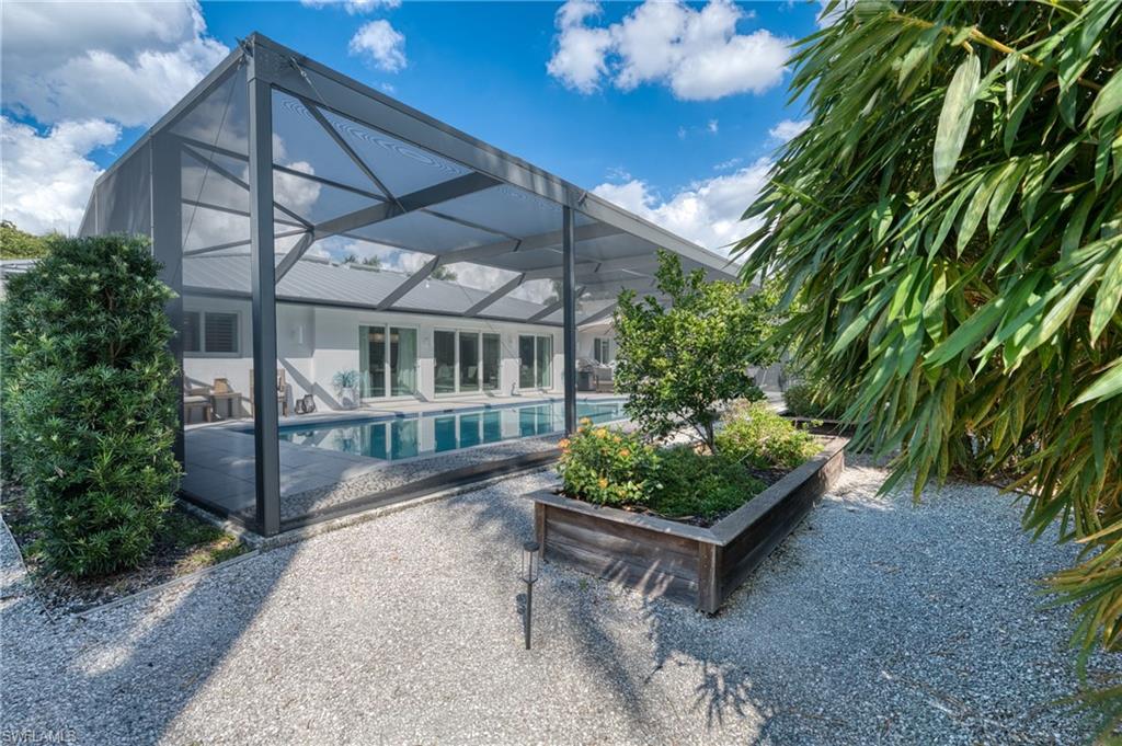 516 Neapolitan Lane Naples, FL 34103 - Photo 36 of 49 Rear view of property with a sunroom, a patio, glass enclosure, and an outdoor pool