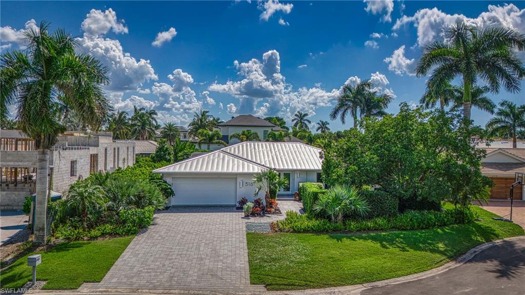 516 Neapolitan Lane Naples, FL 34103 - Photo 4 of 49 View of front facade featuring driveway, an attached garage, stucco siding, and a front lawn