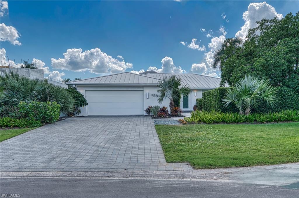 516 Neapolitan Lane Naples, FL 34103 - Photo 5 of 49 Ranch-style house with decorative driveway, a front yard, a garage, and stucco siding