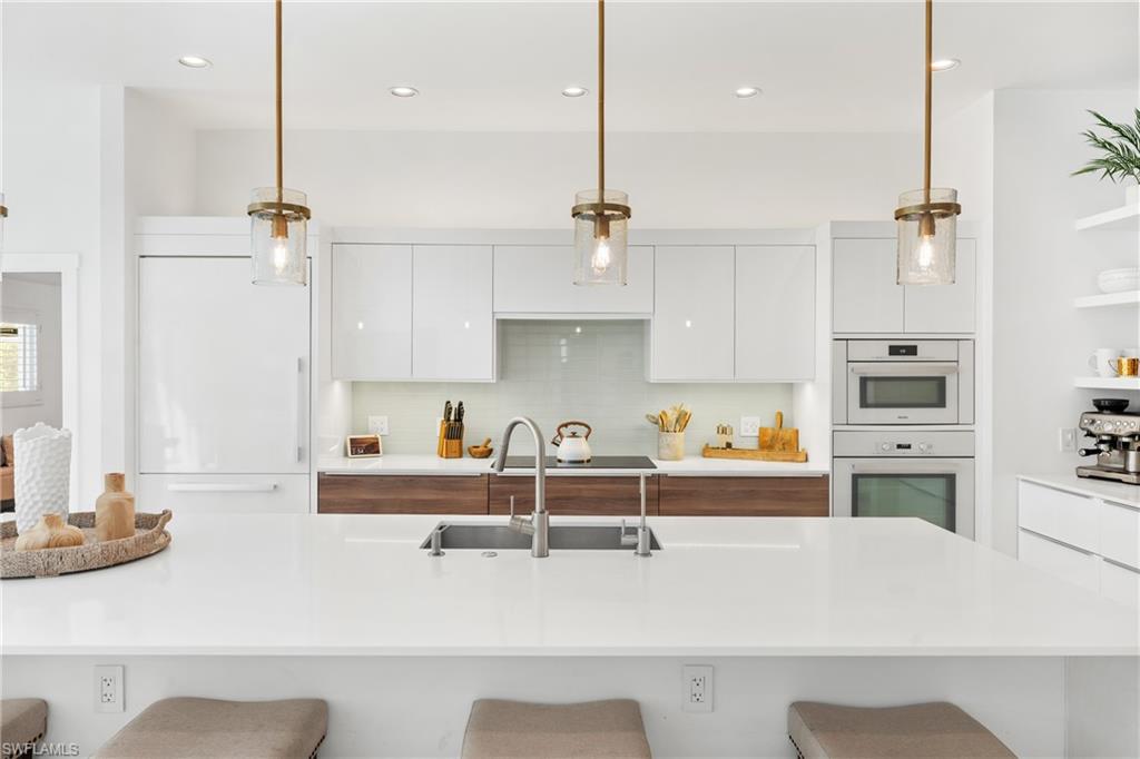 516 Neapolitan Lane Naples, FL 34103 - Photo 7 of 49 Kitchen with white cabinetry, a breakfast bar, modern cabinets, and recessed lighting