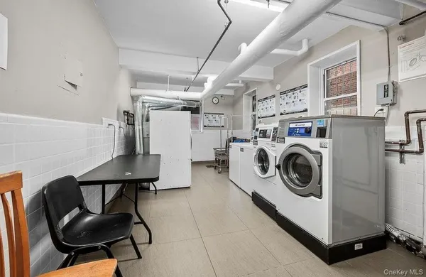 a utility room with dryer washer and stair