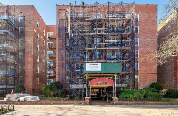 a front view of a building with a garden and plants
