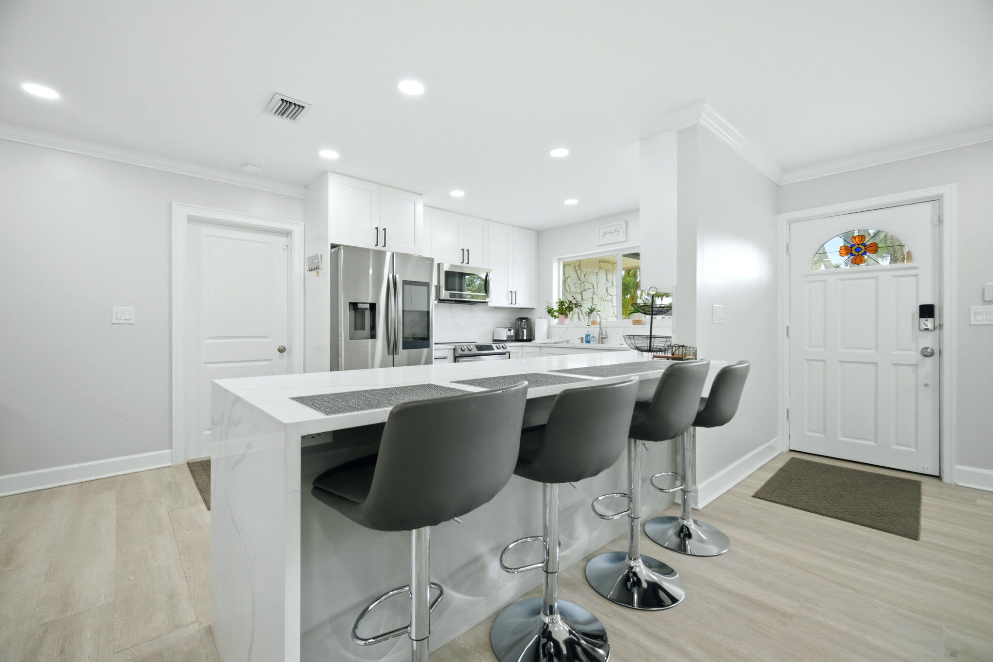 2740 Southeast 7th Street Pompano Beach, FL 33062 - Photo 11 of 34 a kitchen with stainless steel appliances kitchen island hardwood floor and chairs