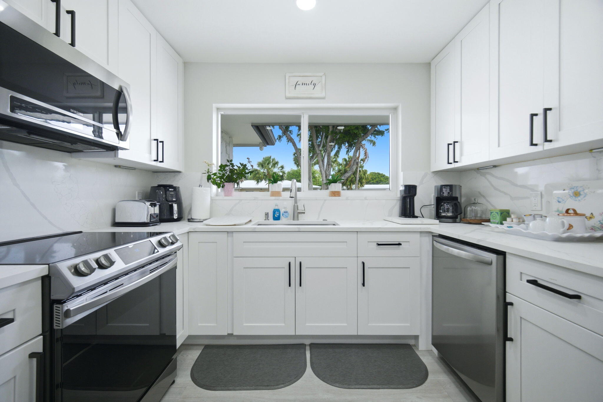 2740 Southeast 7th Street Pompano Beach, FL 33062 - Photo 12 of 34 a kitchen with stainless steel appliances white cabinets and a stove