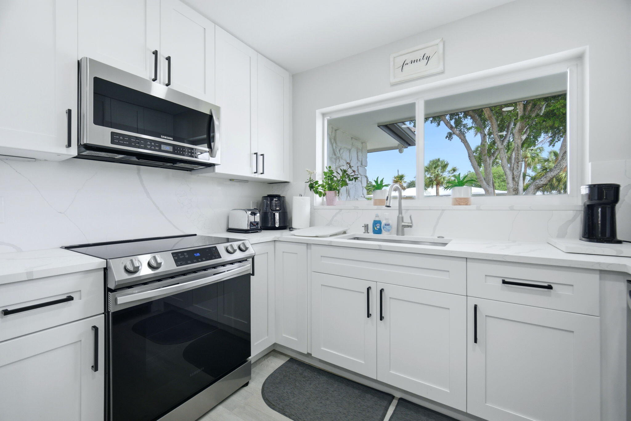 2740 Southeast 7th Street Pompano Beach, FL 33062 - Photo 13 of 34 a kitchen with white cabinets and a stove top oven
