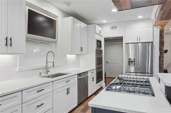 a kitchen with stainless steel appliances a refrigerator sink and cabinets