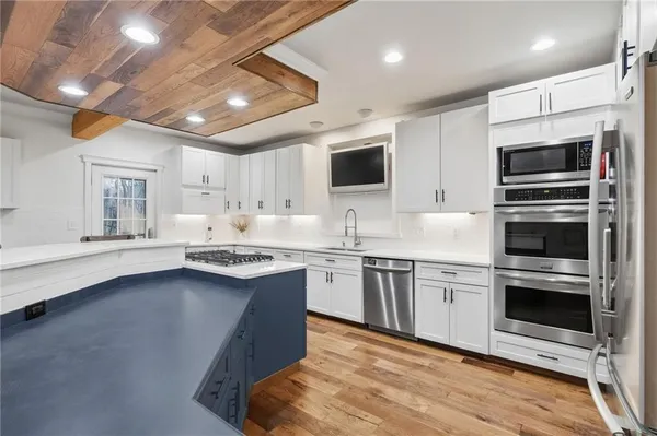 a kitchen with stainless steel appliances granite countertop a sink stove and microwave