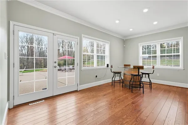 a dining room with wooden floor and windows