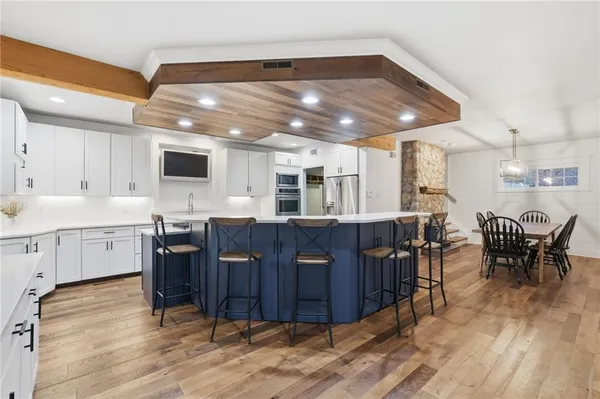 a kitchen with a dining table chairs and wooden floor