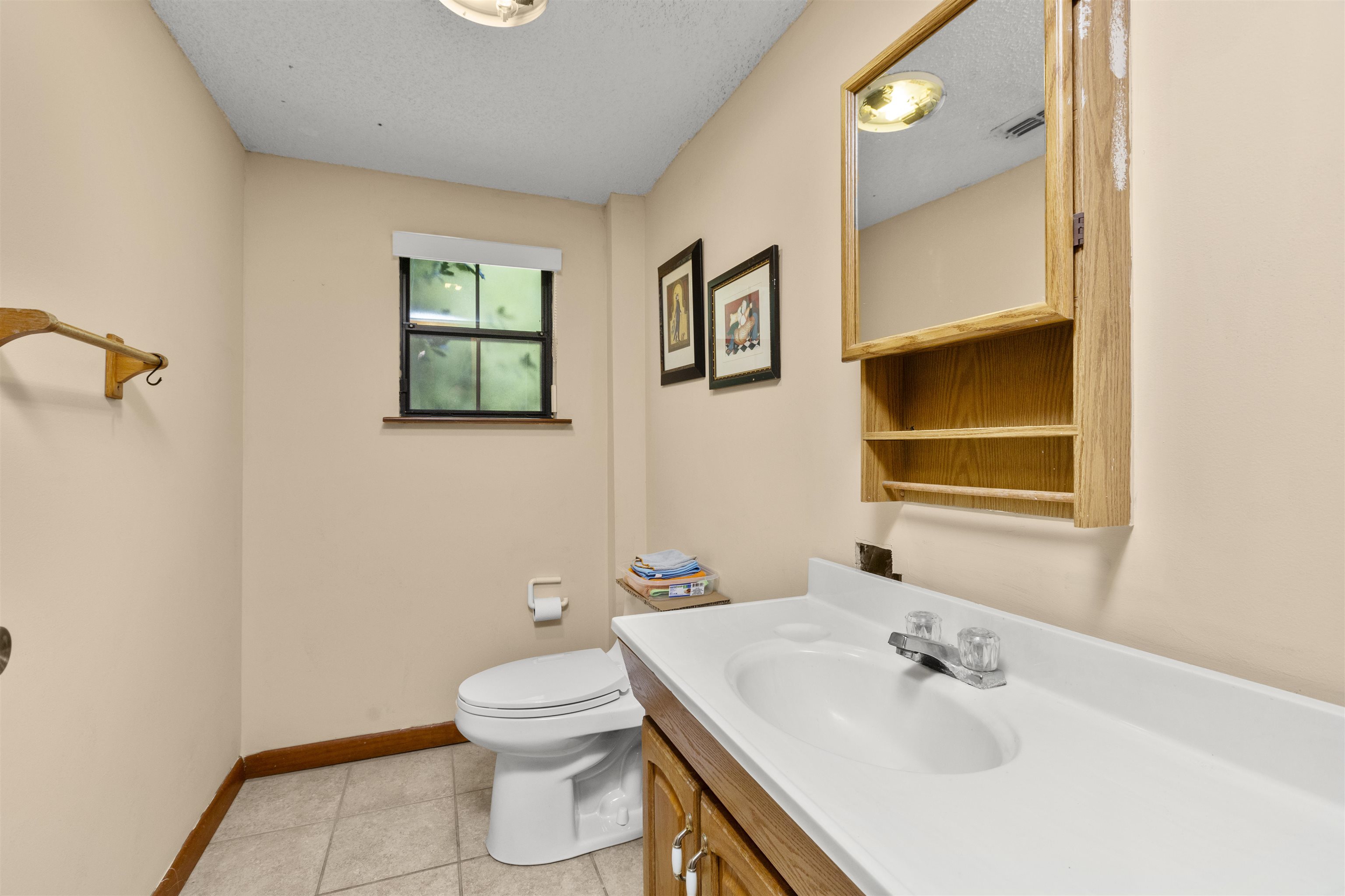 545 Ray Edwards Road St. Augustine, FL 32086 - Photo 16 of 78 Bathroom featuring vanity, light tile patterned floors, and a textured ceiling