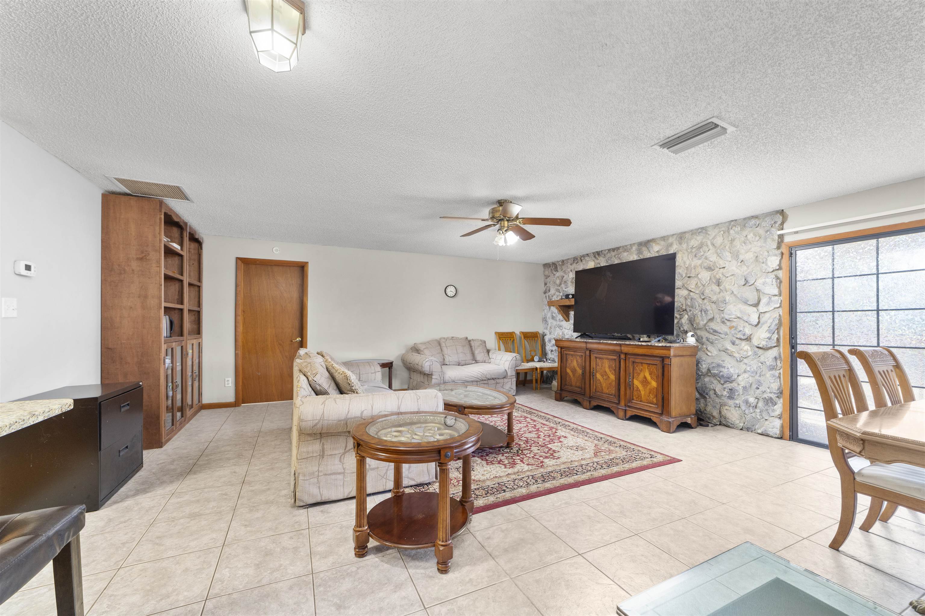 545 Ray Edwards Road St. Augustine, FL 32086 - Photo 24 of 78 Living area with a textured ceiling, ceiling fan, light tile patterned floors, and an accent wall