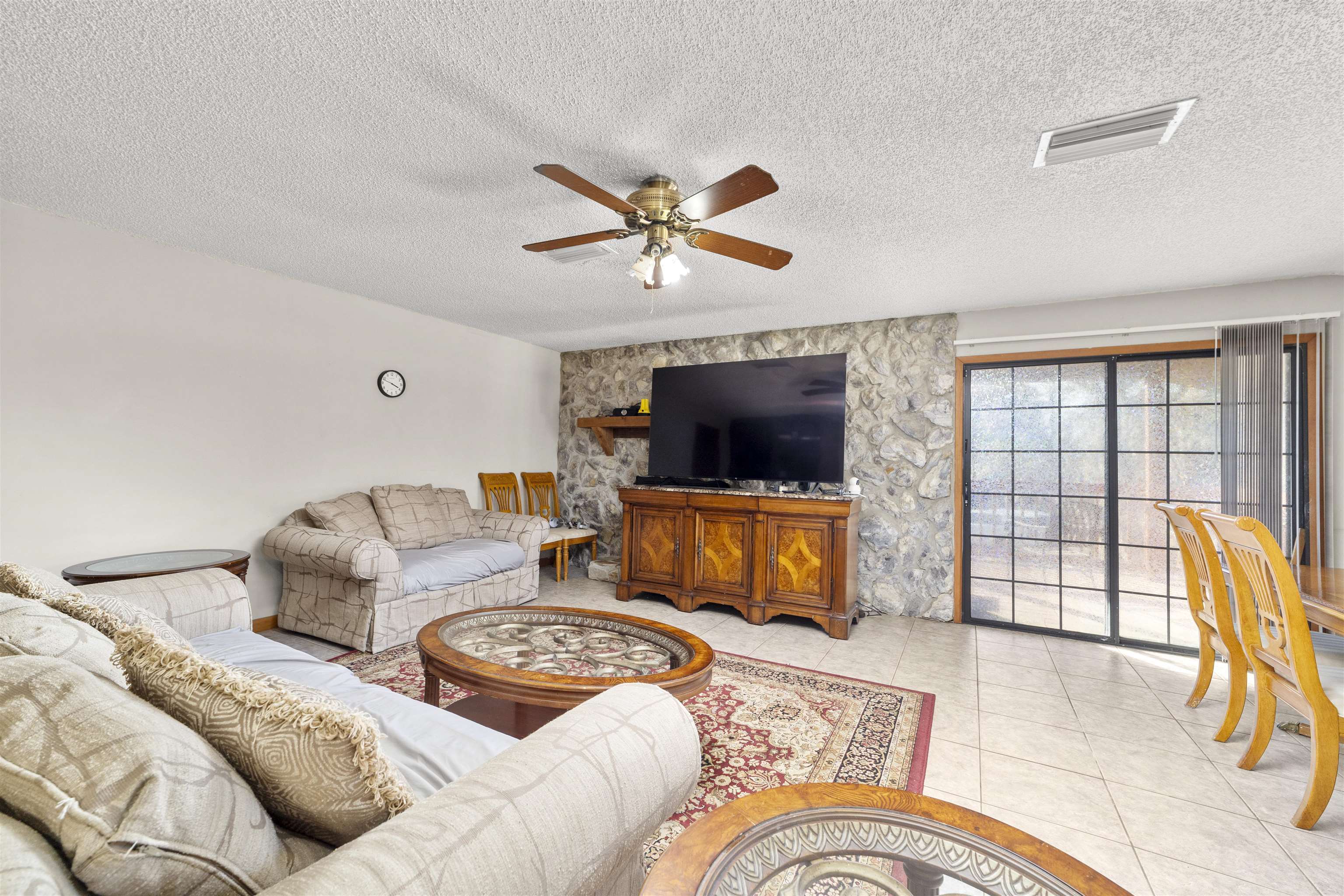 545 Ray Edwards Road St. Augustine, FL 32086 - Photo 25 of 78 Living room with a textured ceiling, light tile patterned flooring, and ceiling fan