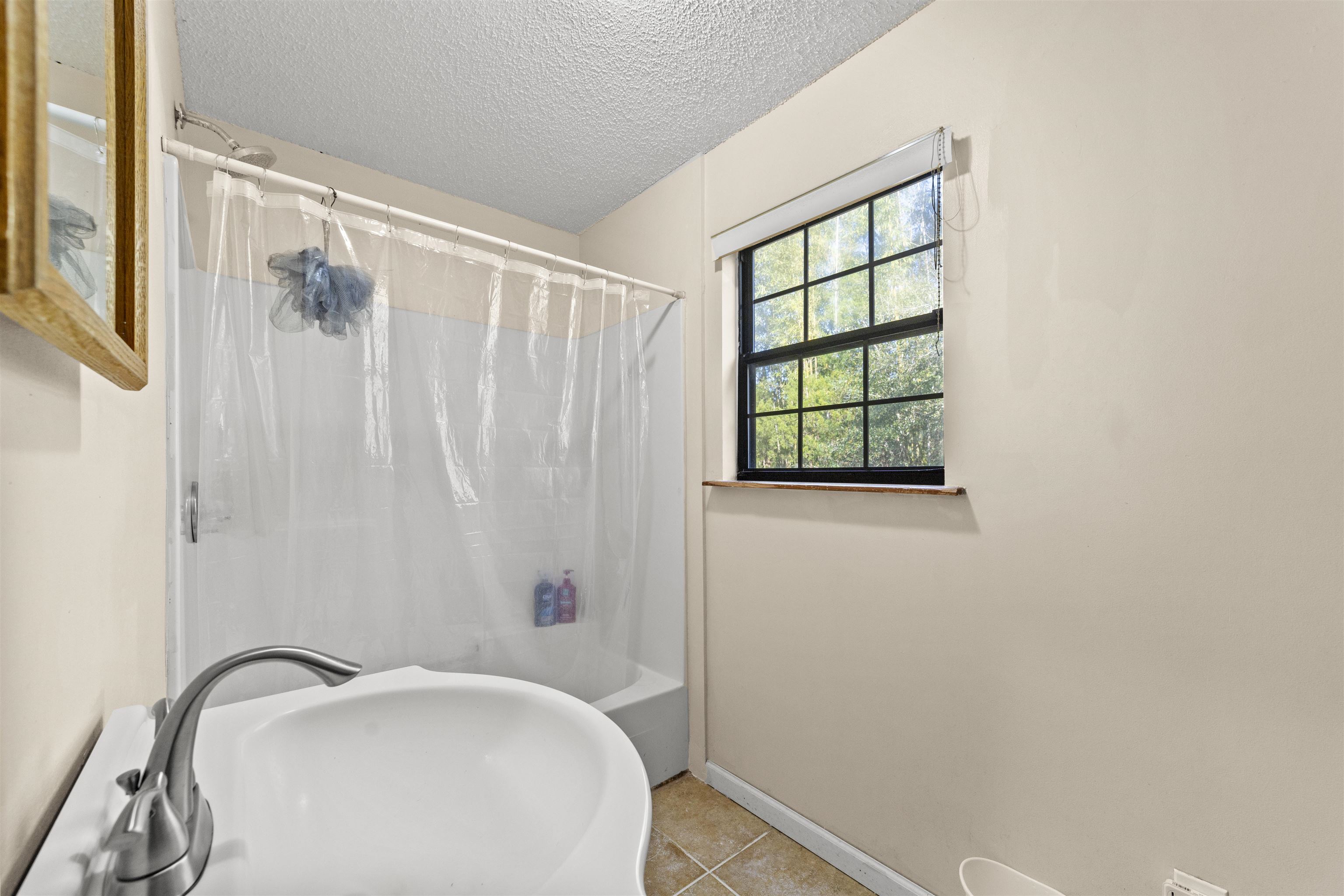 545 Ray Edwards Road St. Augustine, FL 32086 - Photo 33 of 78 Full bathroom featuring shower / bathtub combination with curtain, a textured ceiling, and tile patterned floors