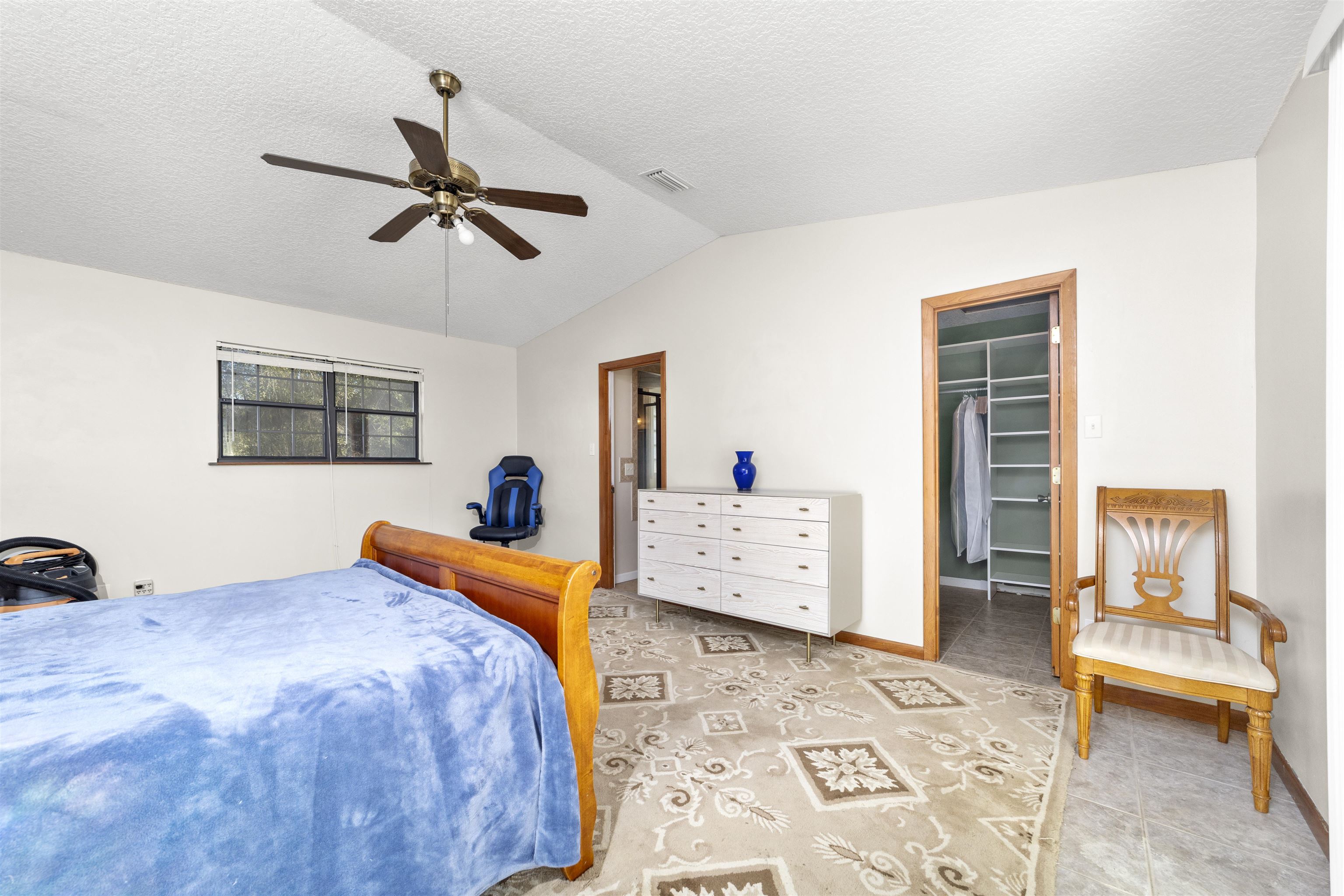 545 Ray Edwards Road St. Augustine, FL 32086 - Photo 39 of 78 Bedroom with a walk in closet, a textured ceiling, ceiling fan, and vaulted ceiling