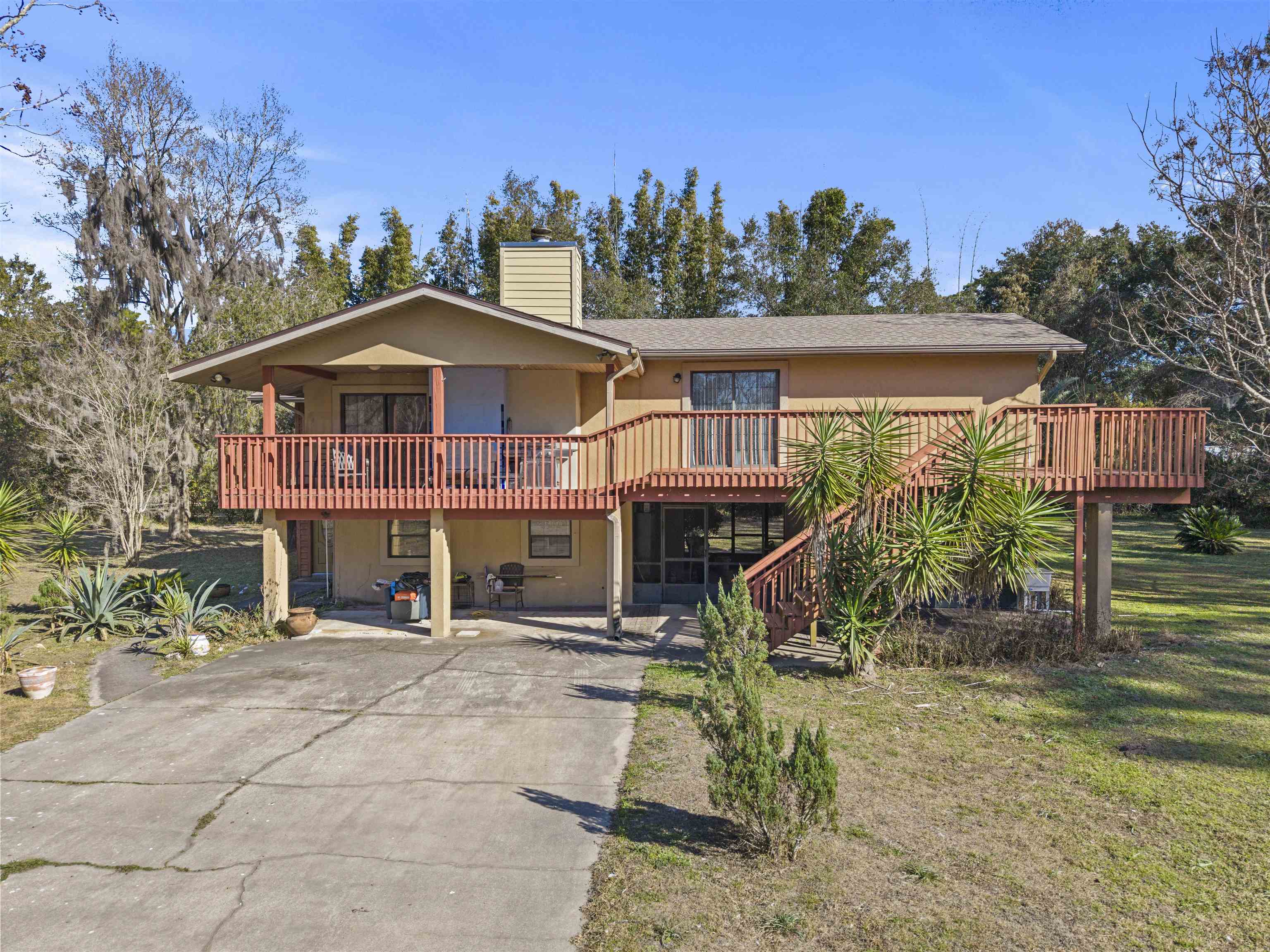 545 Ray Edwards Road St. Augustine, FL 32086 - Photo 69 of 78 View of front of house featuring a chimney, driveway, a front yard, a deck, and stucco siding