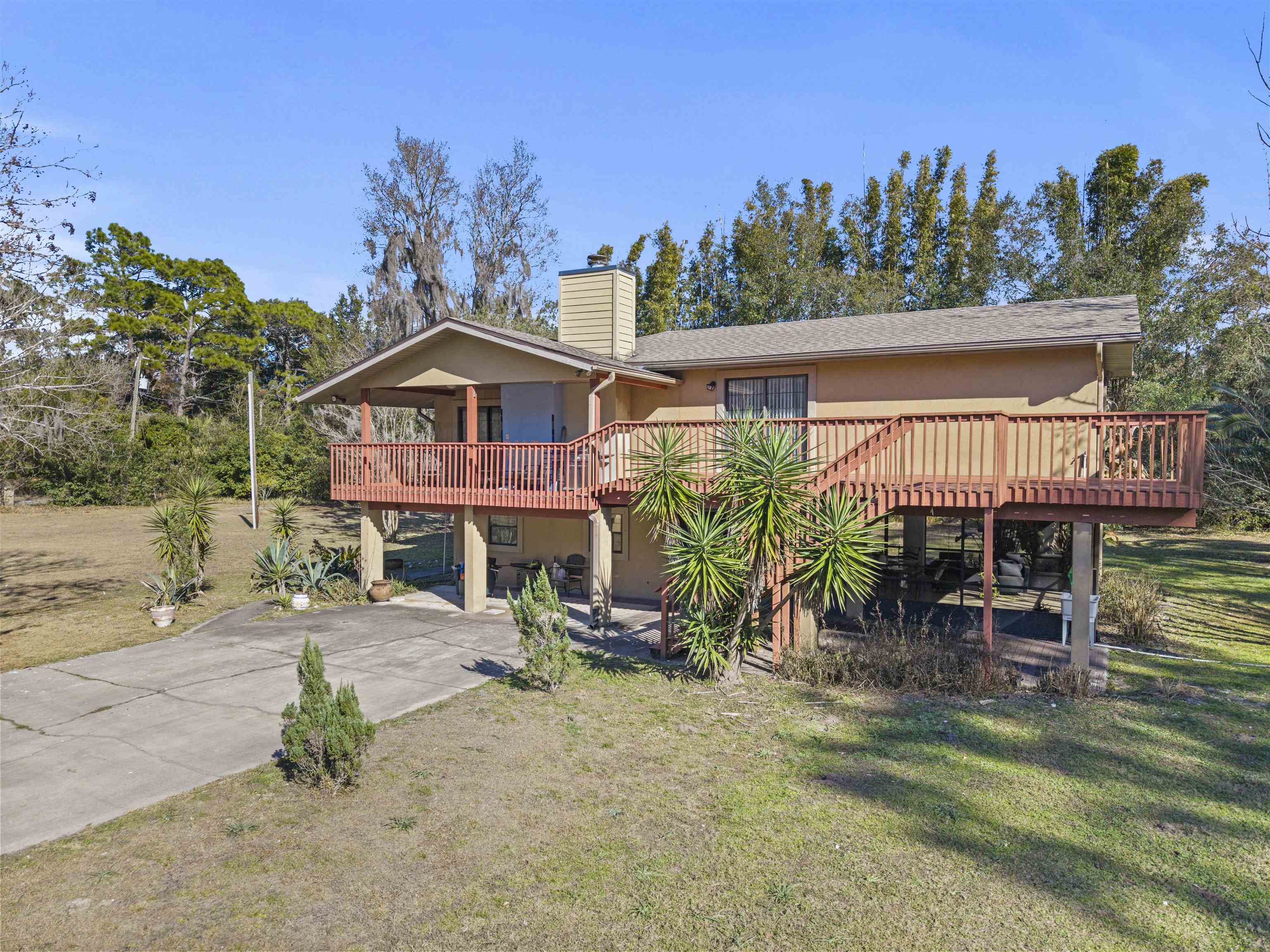 545 Ray Edwards Road St. Augustine, FL 32086 - Photo 70 of 78 View of front of house featuring a front lawn, a patio, a chimney, a wooden deck, and stucco siding