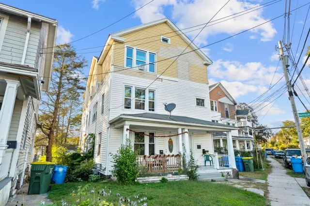 a view of a white building with many windows and a yard