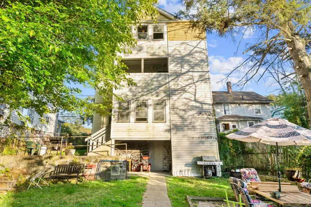 a front view of a building with a garden and plants