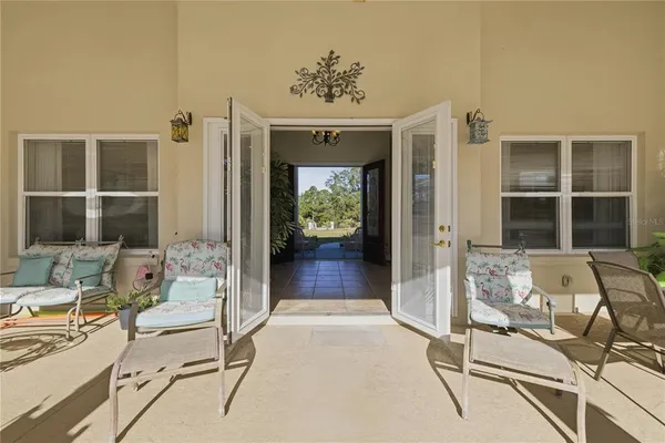 a living room with furniture a chandelier and a large window
