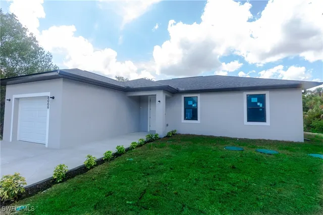 a front view of house with yard and trees around