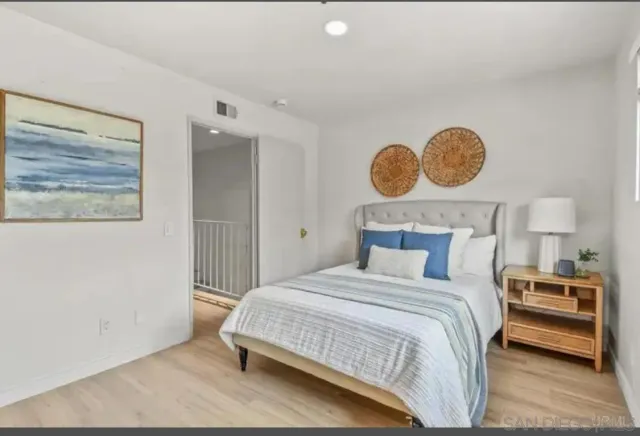 a bedroom with a bed and painting on the wall