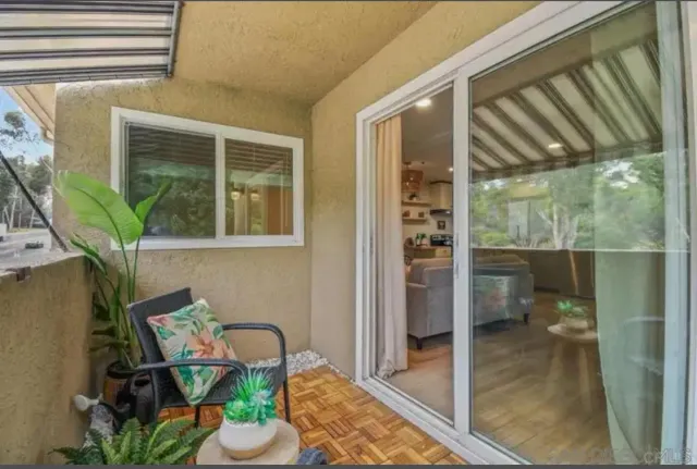 a view of a balcony with chair and potted plants