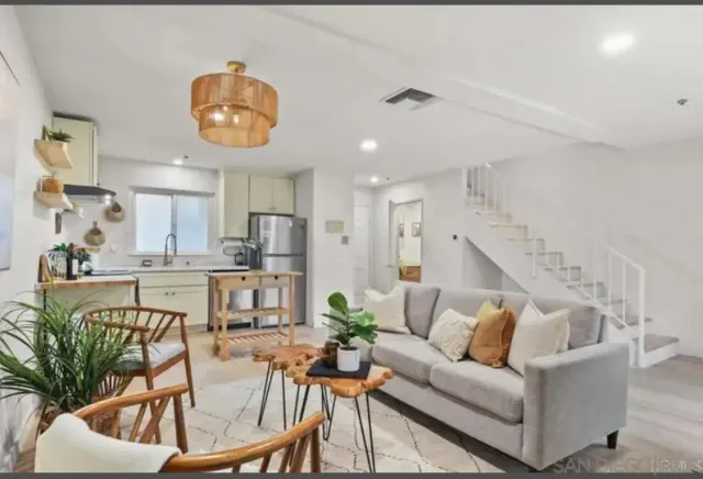 a living room with furniture kitchen and a potted plant