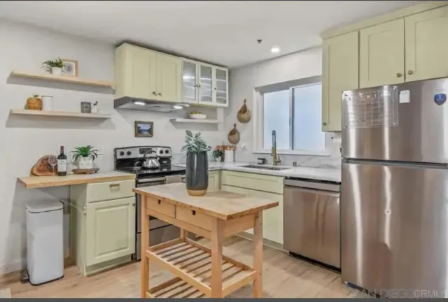 a kitchen with stainless steel appliances granite countertop a stove a refrigerator and a sink