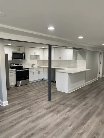 a large kitchen with kitchen island a sink stainless steel appliances and cabinets