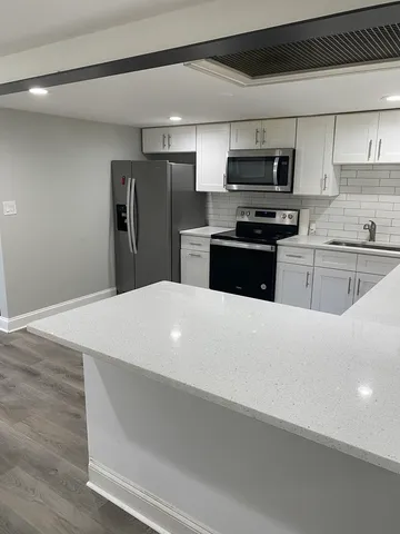 a kitchen with stainless steel appliances a refrigerator microwave and stove