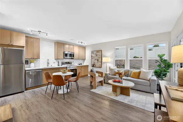 a living room with furniture wooden floor and kitchen view