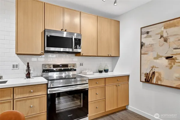 a kitchen with stainless steel appliances granite countertop a stove a microwave and cabinets